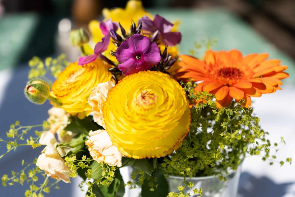 Frühlingshafter Blumenstrauss mit gelben, orangenen und violetten Blumen