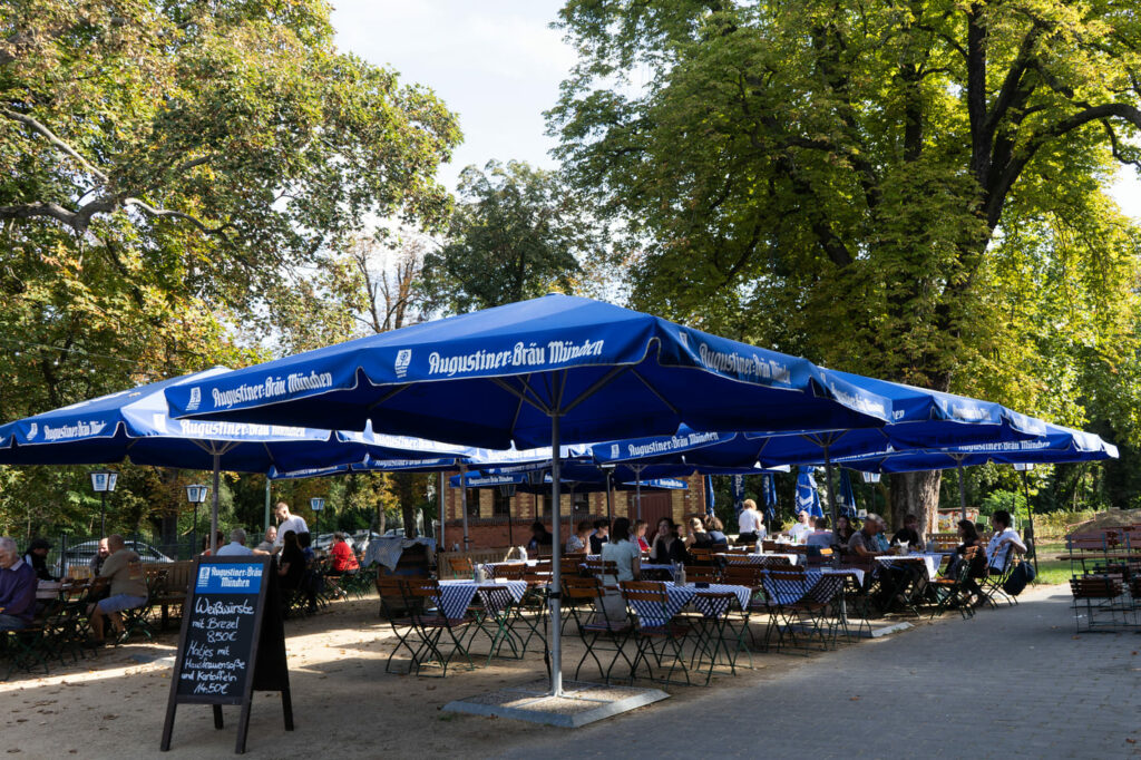 Biergarten am Bürgerbahnhof Potsdam mit Gästen und Sitzbereichen.