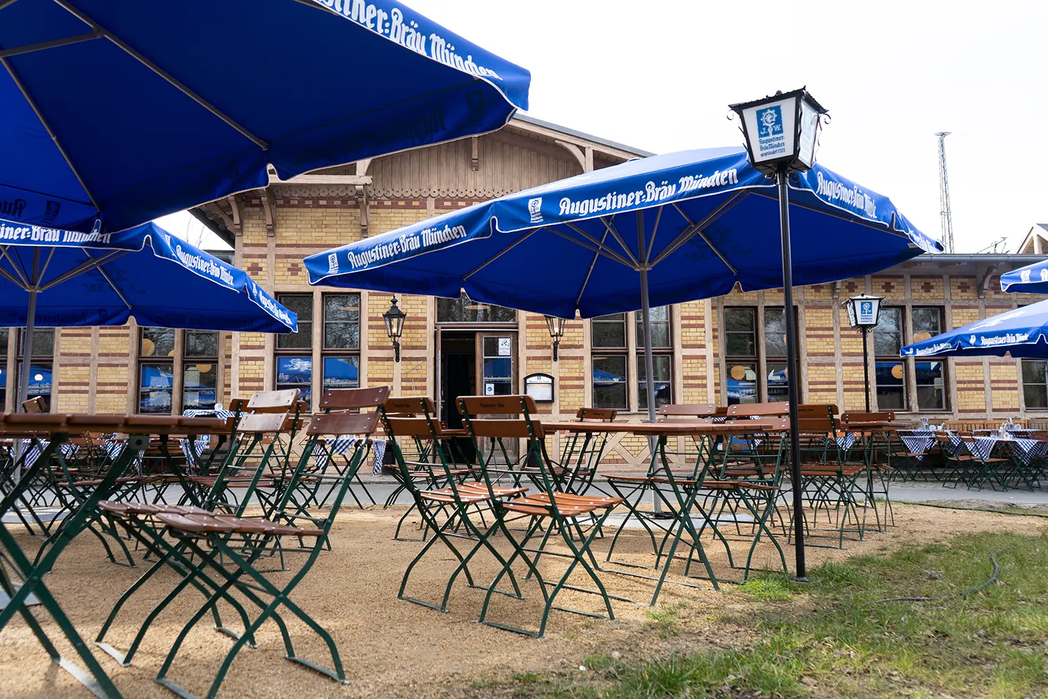 Terrasse des Augustiner am Bürgerbahnhof mit Sitzplätzen vor dem Gebäude.